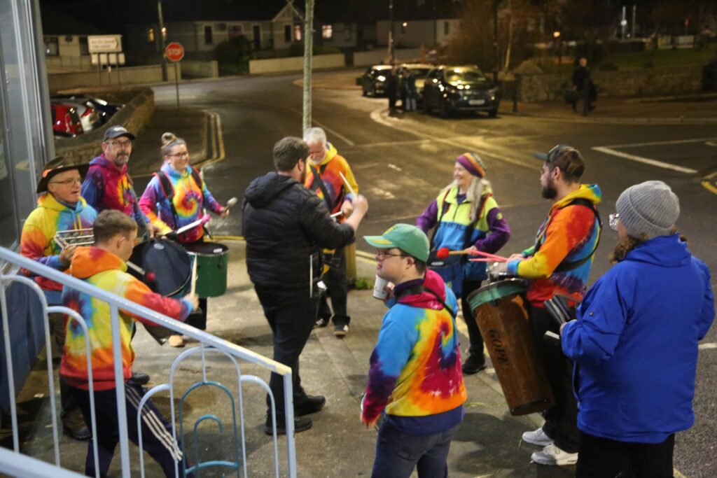 musicians stand outside in a circle playing their instruments