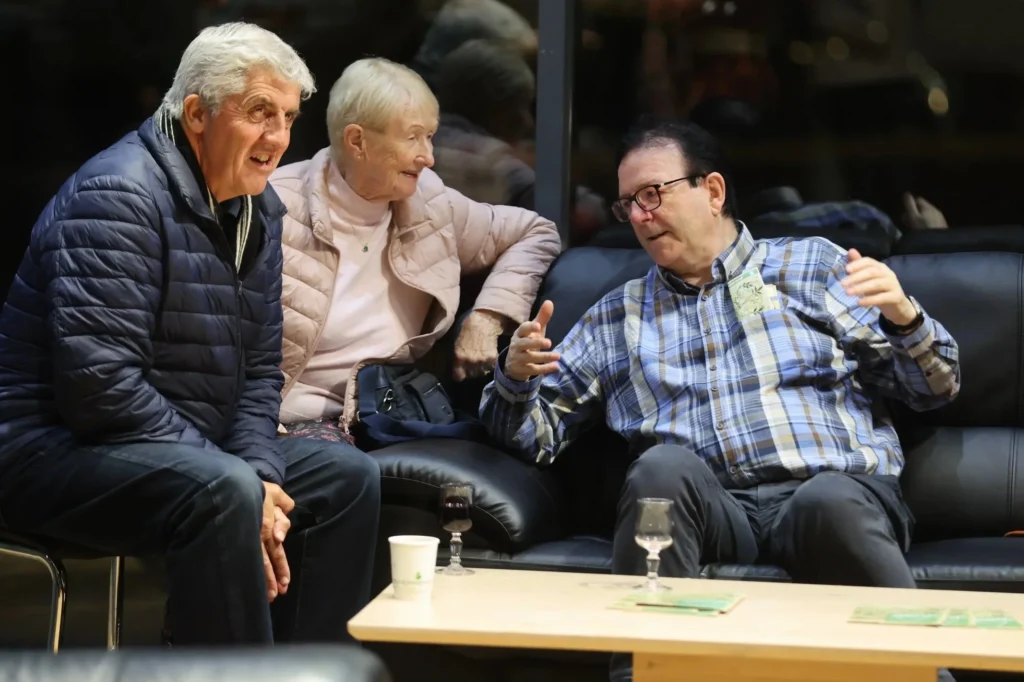 three people sitting down and talking to eachother